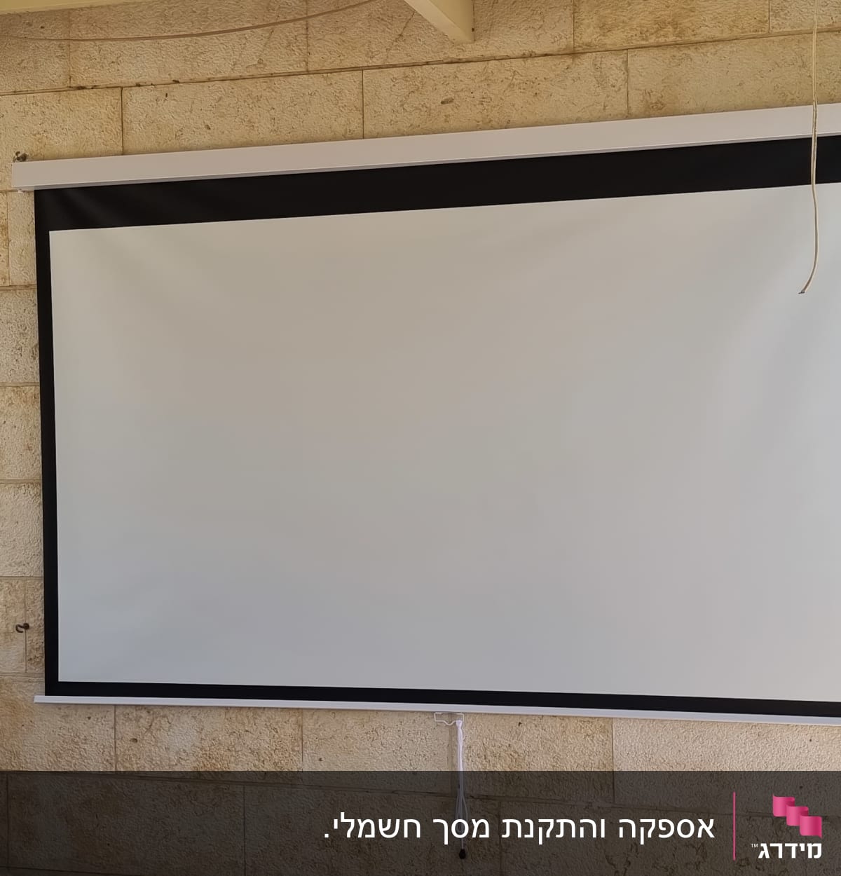 מסך הקרנה מותקן על קיר אבן עם סולם בצד